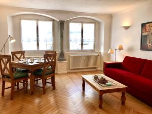 sala de estar con mesa y sofá rojo en Am Stadtpark, en Lindau