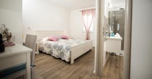 a bedroom with a bed with pink pillows on it at Apartments Villa Laguna with pool in Ražanj