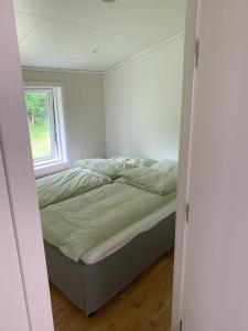 a bedroom with a bed in a room with a window at Sivert´s kontorhotell in Tomrefjord