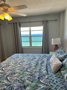 a bedroom with a bed with a view of the ocean at Ponce de Leon Towers in New Smyrna Beach