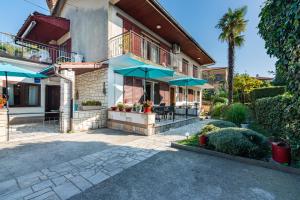 dom z patio z niebieskimi parasolami w obiekcie Apartment Mediteraneo w mieście Opatija