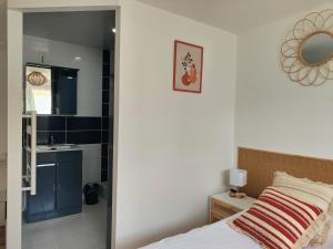 1 dormitorio con cama, lavabo y espejo en Le FAYA, en Pouzauges