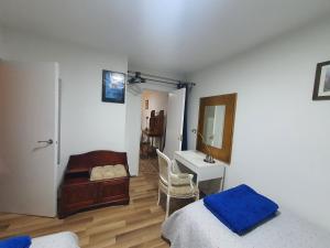 een slaapkamer met een bed, een bureau en een spiegel bij Limehouse Guest House Central East London in Londen