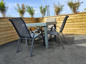 dos sillas y una mesa frente a una valla en Le FAYA, en Pouzauges