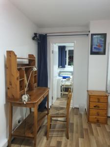 een kamer met een houten bureau en een stoel bij Limehouse Guest House Central East London in Londen