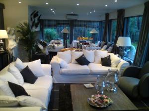 una gran sala de estar con sofás blancos y una mesa. en Le Comptoir Des Sables, en Biscarrosse-Plage