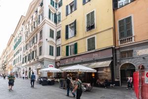 eine Gruppe von Menschen, die eine Straße mit Gebäuden entlanggehen in der Unterkunft Cattedrale di San Lorenzo rooms in Genua