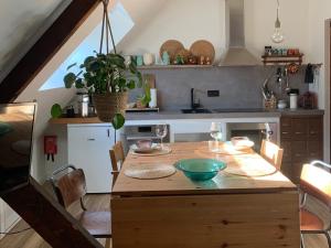 una cocina con una mesa de madera con un tazón. en Zolder appartement Le Grenier, en Dilsen-Stokkem