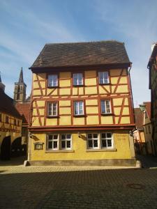 a large yellow and brown building on a street at China Restaurant Hotel Lotus in Rothenburg ob der Tauber