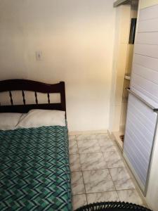 a bedroom with a bed and a tiled floor at Kitnet para 5 pessoas com cozinha perto do aeroporto in Natal