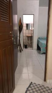 a hallway of a bathroom with a sink and a mirror at Kitnet para 5 pessoas com cozinha perto do aeroporto in Natal
