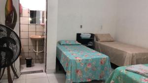 a small room with two tables and a bed at Kitnet para 5 pessoas com cozinha perto do aeroporto in Natal