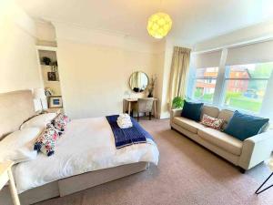 a bedroom with a bed and a couch at Spacious & Bright 3 bed Harrogate Apartment in Harrogate