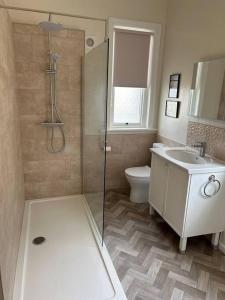 a bathroom with a shower and a toilet and a sink at Spacious & Bright 3 bed Harrogate Apartment in Harrogate