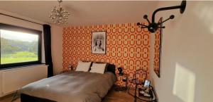 a bedroom with a bed with an orange wall at Paulette à bicyclette in Méry