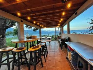 a patio with a bar with stools and a view at Refugio del Volcan Casitas in San Pedro La Laguna