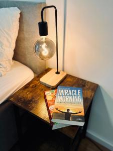 a book on a table next to a bed with a lamp at Elegantes Refugium in Düren in Düren - Eifel