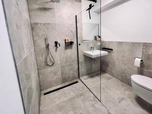 ein Bad mit einer Dusche und einem Waschbecken in der Unterkunft Elegantes Refugium in Düren in Düren - Eifel