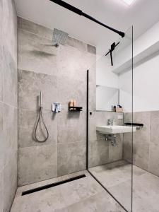 ein Bad mit einer Dusche und einem Waschbecken in der Unterkunft Elegantes Refugium in Düren in Düren - Eifel