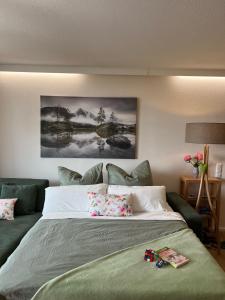 a bedroom with a large bed with a green couch at Hecht Ferienvermietung - Fewo Turmfalke 2-Zimmer-Appartement mit Sauna und Schwimmbad in Sankt Englmar