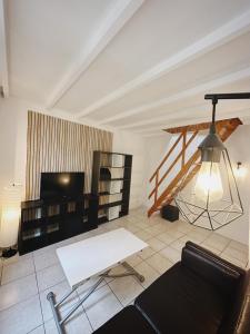- un salon avec un canapé et une télévision dans l'établissement La Suite - Charmant duplex proche Paris, à Villejuif