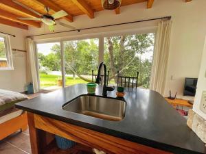a kitchen with a sink and a large window at Refugio del Volcan Casitas in San Pedro La Laguna