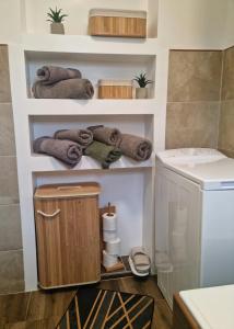a bathroom with a washing machine and towels on shelves at Oaza031 in Užice +25 photos