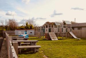 un patio con parque infantil y equipo de juegos en 102, Duckpool Lodge, en Bude