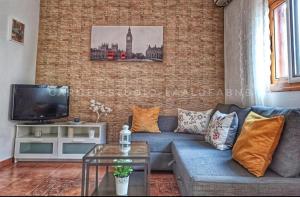 a living room with a blue couch and a brick wall at Vv CASA JULIANA- Coqueta casa entre montañas. in La Aldea de San Nicolas