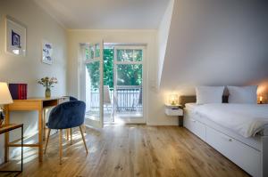 - une chambre avec un lit, un bureau et une fenêtre dans l'établissement Traumhaus Auri in Prerow Ostsee auf dem Darß mit Kamin und Sauna und Garten, à Prerow