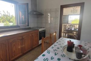 a kitchen with a table and a dining room at Sabbia Suites Casa Malvasía in Mozaga