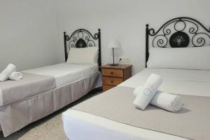 a bedroom with two beds and a dresser with a lamp at Sabbia Suites Casa Malvasía in Mozaga