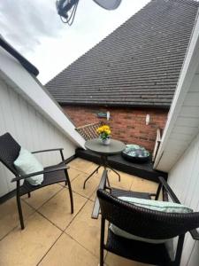 a patio with two chairs and a table on a roof at BS - Luxury 4 bed apartment with garage in town centre in Stratford-upon-Avon