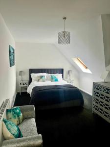 a bedroom with a bed and a couch at BS - Luxury top floor 4 bed apartment with garage in town centre - NO LIFT in Stratford-upon-Avon