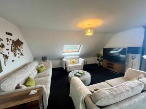 a living room with two couches and a tv at BS - Luxury top floor 4 bed apartment with garage in town centre - NO LIFT in Stratford-upon-Avon