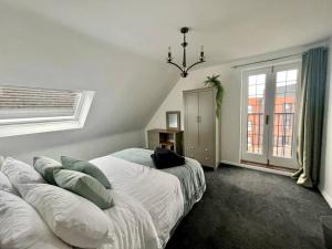 1 dormitorio con 2 camas y lámpara de araña en BS - Luxury 4 bed apartment with garage in town centre, en Stratford-upon-Avon