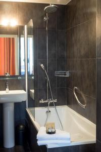 La salle de bains est pourvue d'une douche, d'une baignoire et d'un lavabo. dans l'établissement Hôtel Victoria Châtelet, à Paris