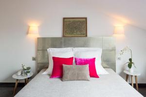 a bedroom with a bed with two pink pillows at Hôtel Victoria Châtelet in Paris