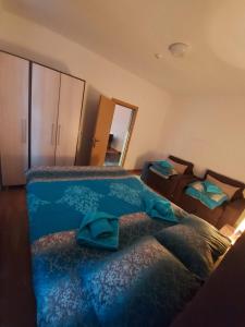 a bedroom with a large bed with a blue blanket at Apartmansko naselje DVORI in Kopaonik