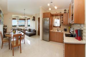 a kitchen and living room with a table and a dining room at Villa Alonia in Skala