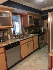 a kitchen with wooden cabinets and a sink at Spacious Light & Bright Private Apartment in Great Falls