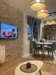 a living room with a tv on a brick wall at Boutique apartment Bansko Bell Tower in Bansko