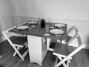 einen Esstisch mit Tellern und Gläsern darauf in der Unterkunft Rockcliffe Retreat, Stylish Coastal Apartment in Whitley Bay