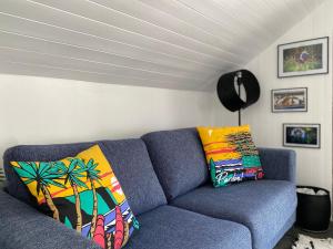 um sofá azul com almofadas coloridas numa sala de estar em La Kaz montagne em Briançon