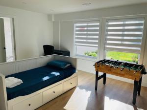 a bedroom with a bed and a table and windows at Luxury Smart Home ~ Perfect Getaway Resort/Sleeps 14 in Langley