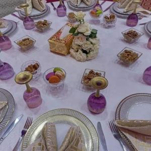 een tafel met paarse vazen en borden met voedsel bij HOTEL OUM EL FADL in Fkih Ben Salah