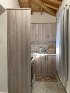 a kitchen with wooden cabinets and an open door at Kalliopi Beach house in Kalliópi