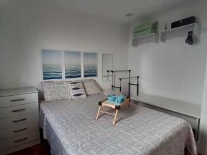 a bedroom with a bed with a table on it at Solar Canto do Forte in Praia Grande