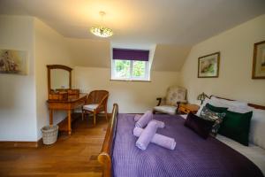 a bedroom with a bed with a stuffed animal on it at The Farthings Cotswolds Holiday Cottage in Chipping Campden
