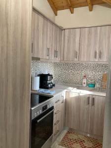 a kitchen with wooden cabinets and a stove top oven at Kalliopi Beach house in Kalliópi